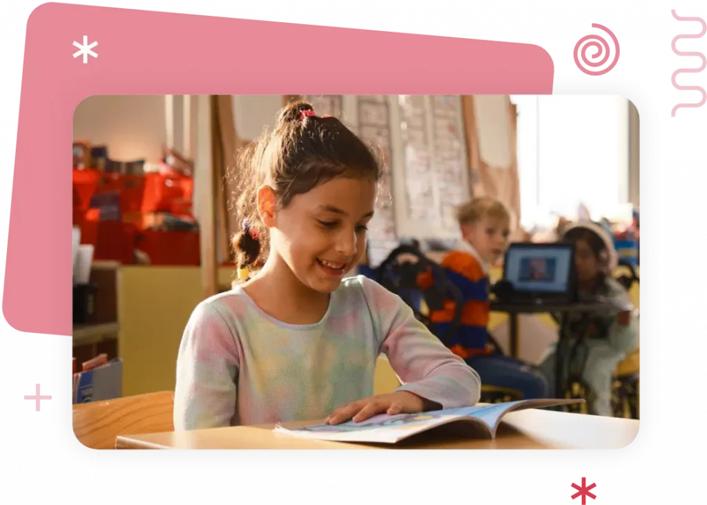 A young girl immerses herself in the science of reading at a classroom desk, surrounded by peers and diverse educational materials.