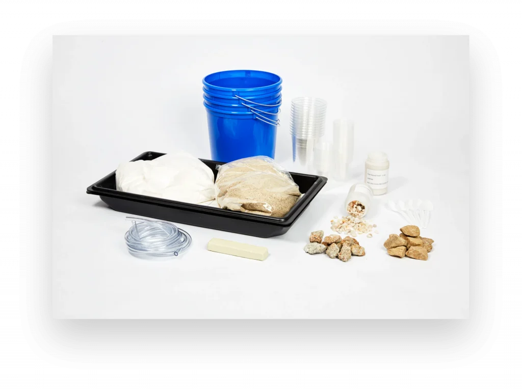 A collection of gardening supplies including a blue bucket, soil bags, plastic cups, hose, fertilizer pellets, and a black tray on a white background.